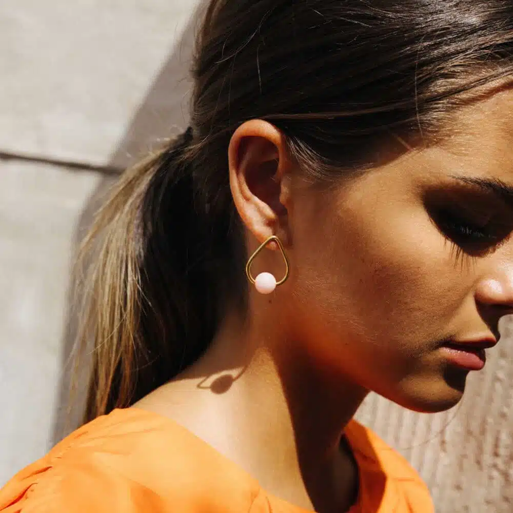 triangular gold plated pink earrings on girl